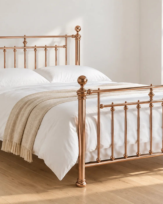 Aurora rose gold Victorian style metal bed frame, shown in a bright UK bedroom