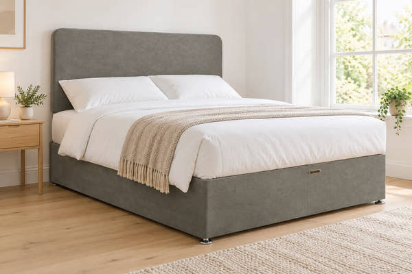 Grey suede divan bed base with 2 drawers and a curved headboard, in a bright UK bedroom (bedding for illustration, mattress not included)