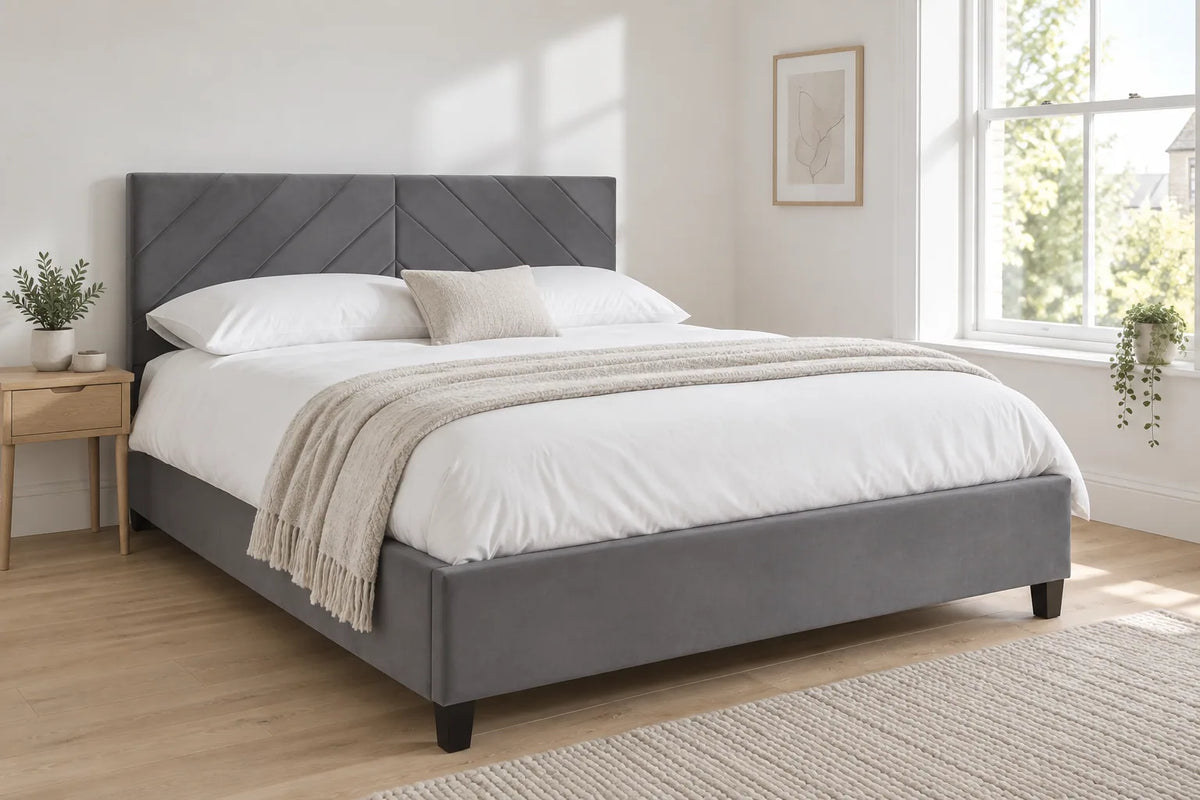 Hoxton grey velvet ottoman bed with a chevron headboard, shown in a bright UK bedroom