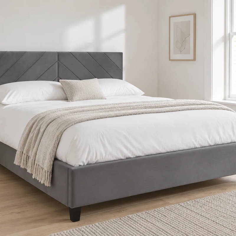 Hoxton grey velvet ottoman bed with a chevron headboard, shown in a bright UK bedroom