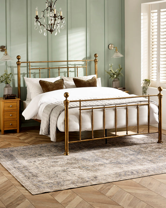 Julian Bowen Aurelia metal bed in brass effect, in a bedroom with green panelled walls