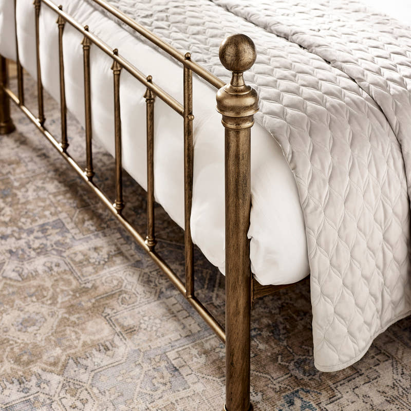 Aurelia bed: the brass effect footboard post and bars, close up