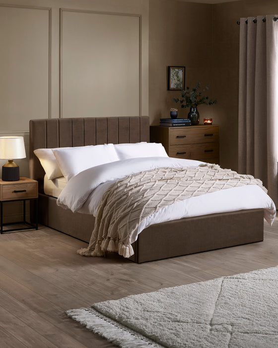 Julian Bowen Aylen ottoman bed in chocolate brown velvet with a channelled headboard, in a bedroom