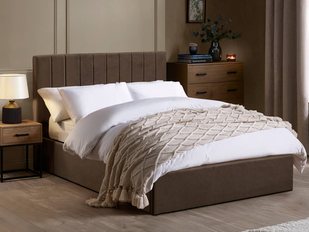 Julian Bowen Aylen ottoman bed in chocolate brown velvet with a channelled headboard, in a bedroom