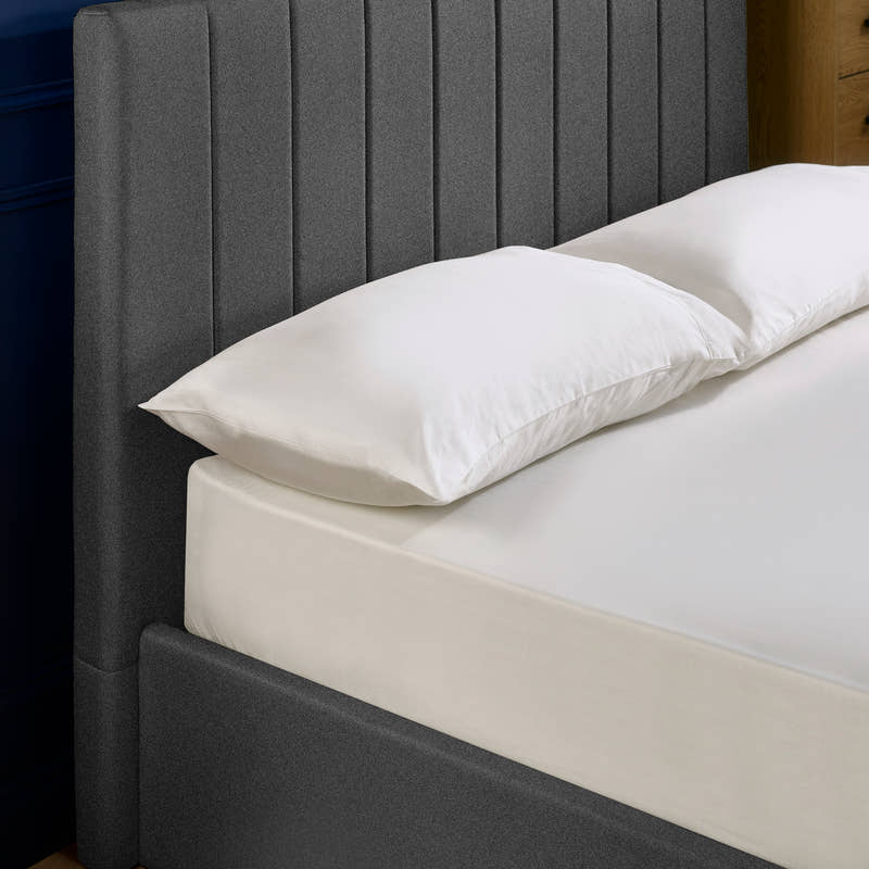 Aylen bed: dark grey headboard padded in vertical channels, close up
