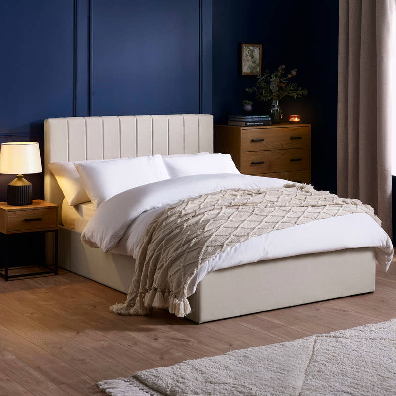 Julian Bowen Aylen ottoman bed in oatmeal linen effect fabric, in a bedroom with blue walls