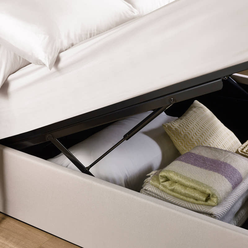Aylen ottoman bed: gas lift raising the oatmeal base over folded blankets, close up