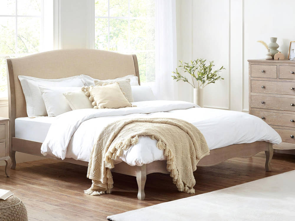 Julian Bowen Camille limed oak bed with curved oatmeal linen headboard, in a bright bedroom