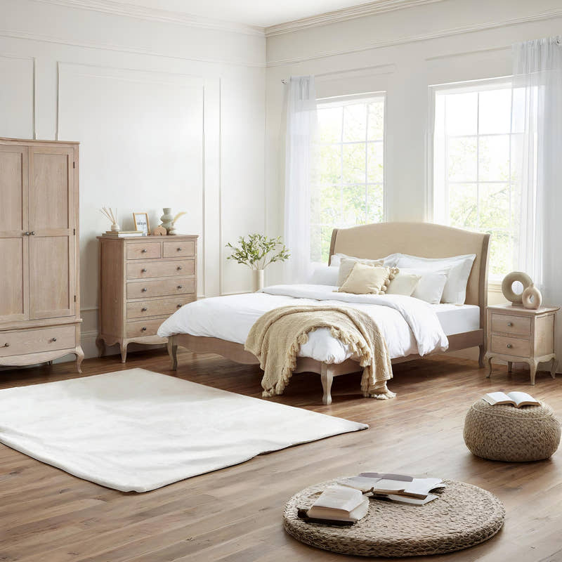 Camille limed oak bed with matching bedroom furniture, in a large room with wooden floor