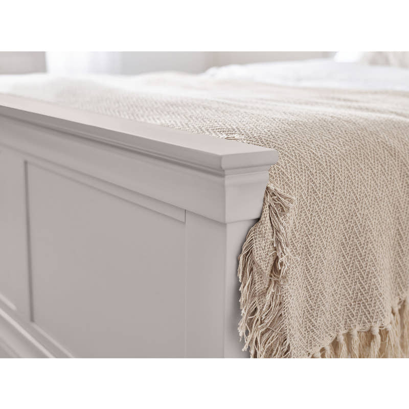 Clermont bed: the light grey panelled footboard with a throw, close up