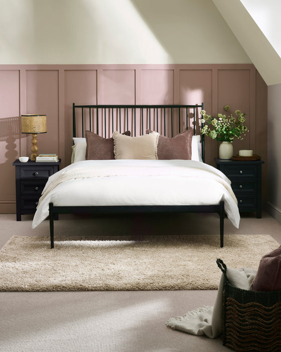 Julian Bowen Floyd black metal spindle bed, in a bedroom with pink panelled walls