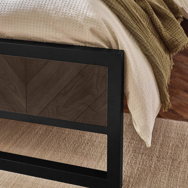 Harrison bed: black metal footboard with a herringbone effect panel, close up