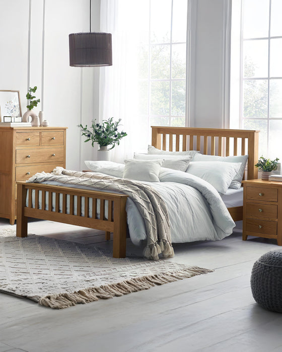 Julian Bowen Mallory oak bed with a high slatted footend, in a bright bedroom