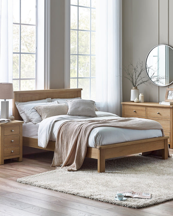 Julian Bowen Memphis limed oak bed with a panelled headboard, in a bright bedroom