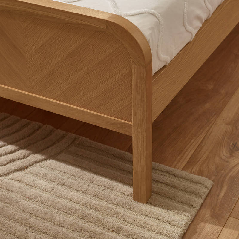 Milo bed: the chevron footboard and rounded oak border, close up
