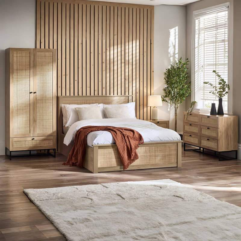 Julian Bowen Padstow oak effect rattan ottoman bed in a large bedroom, wide view