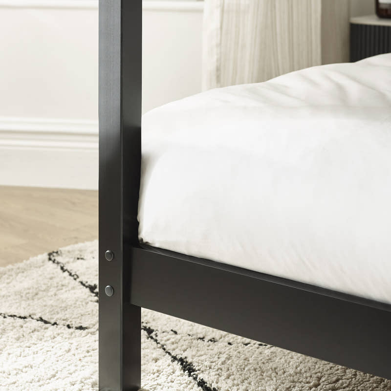 Roxanne canopy bed: black post and side rail in a bedroom, close up