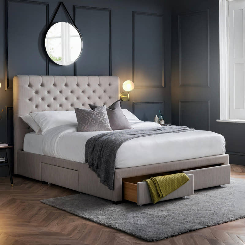 Julian Bowen Wilton 4 drawer bed in light grey with a drawer open, in a dark panelled bedroom