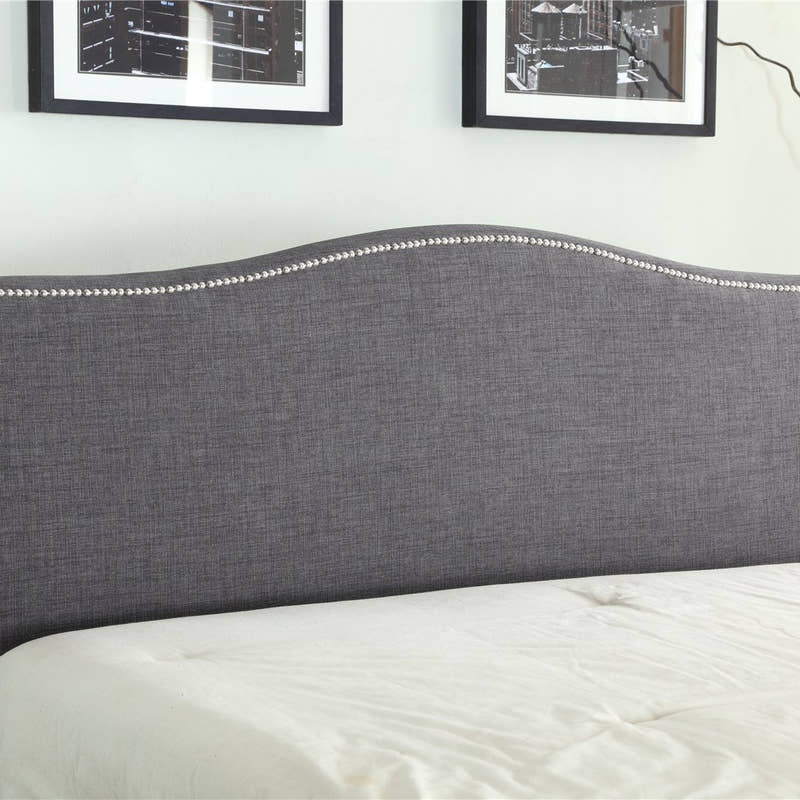 Bexley ottoman bed: curved grey fabric headboard with a studded edge, close up