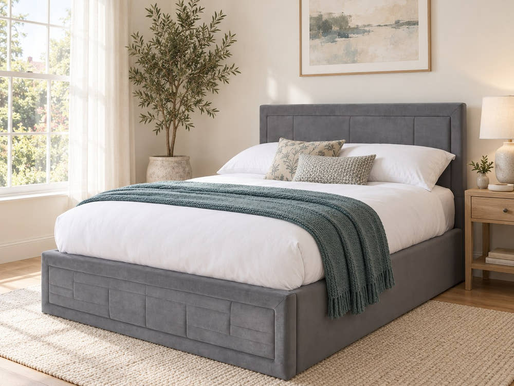 Holland grey velvet ottoman bed frame with a panelled headboard in a bright bedroom (AI-generated illustration of this frame; bedding for illustration, mattress not included)