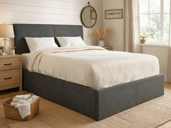 Sydenham grey fabric ottoman bed in a bedroom, made up with cream bedding
