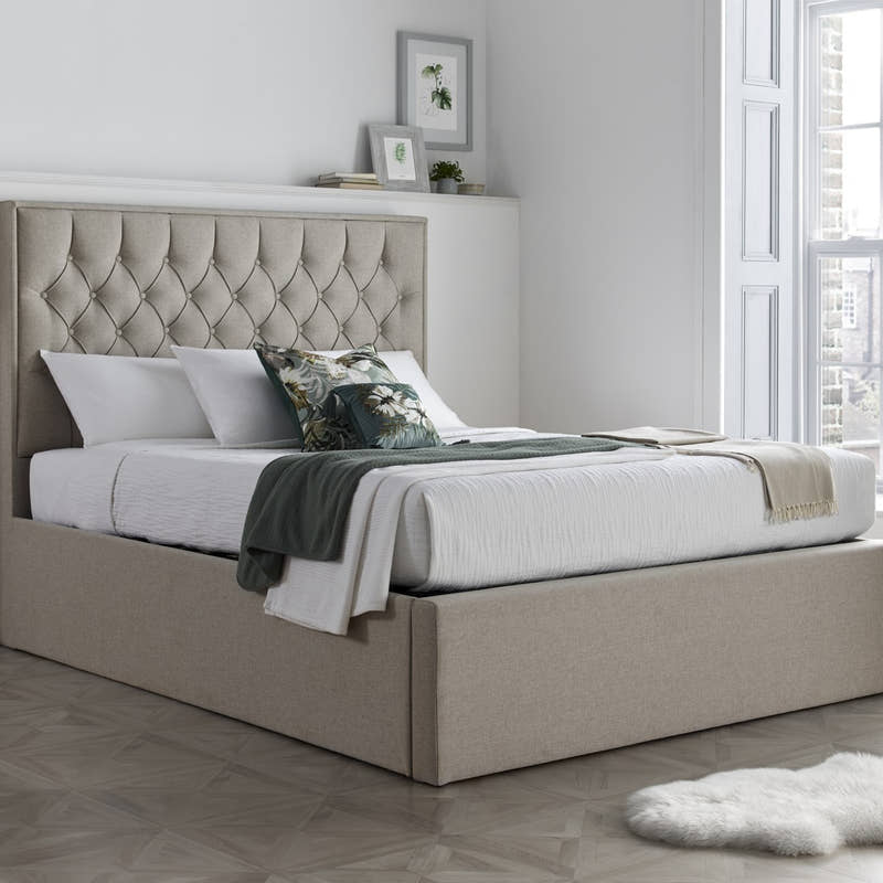Wembley fabric ottoman bed in oatmeal, closed, in a bedroom