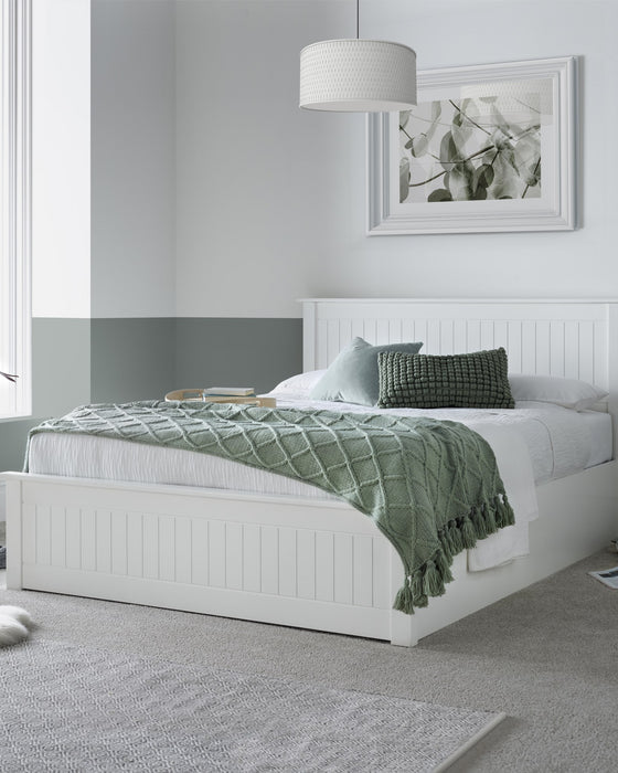 Acton wooden ottoman bed in white, closed, in a bedroom