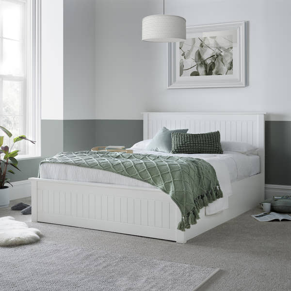 Acton wooden ottoman bed in white, closed, in a bedroom