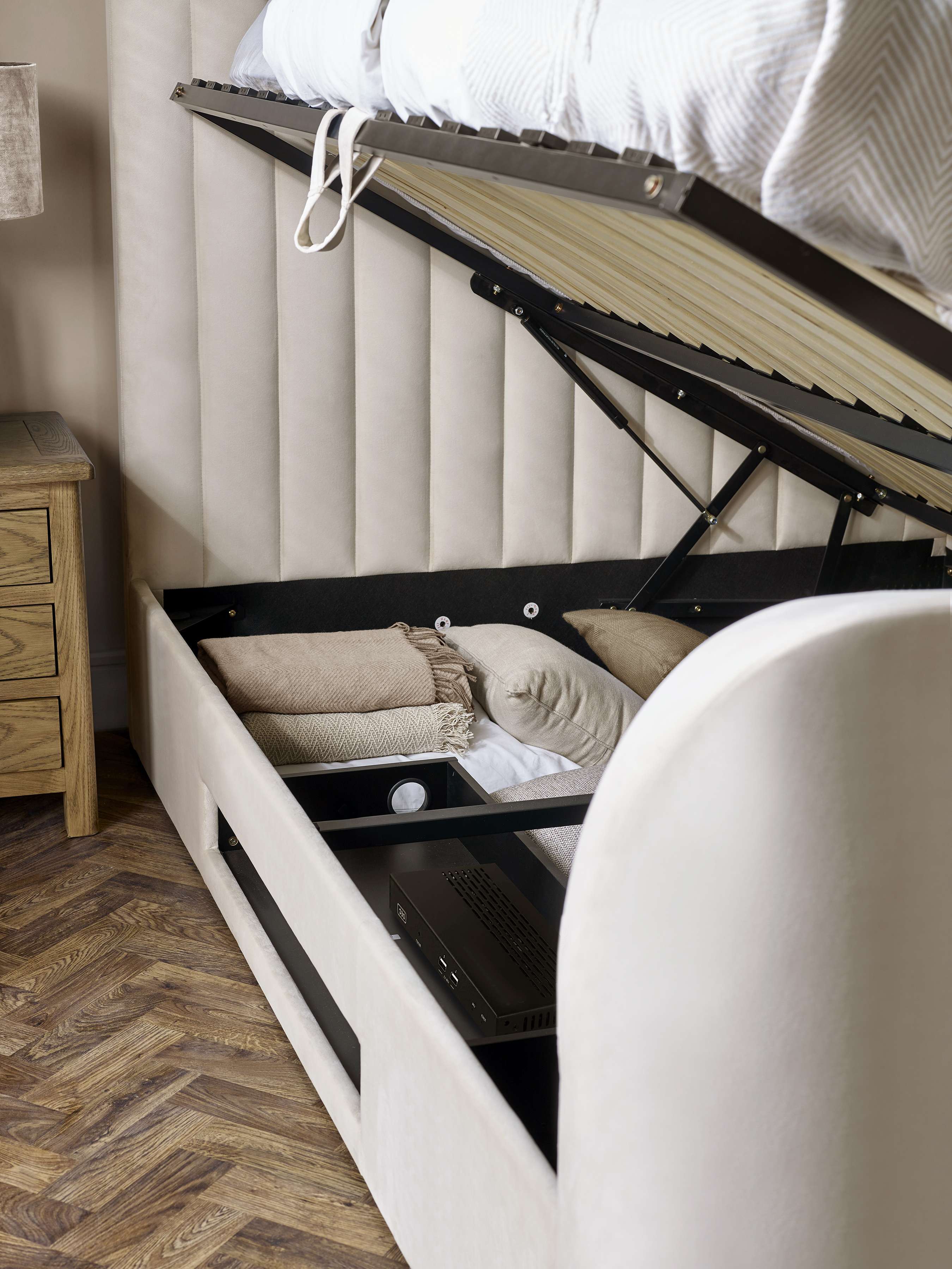 Alana TV bed: the gas lift base raised from the side to show the storage, close up