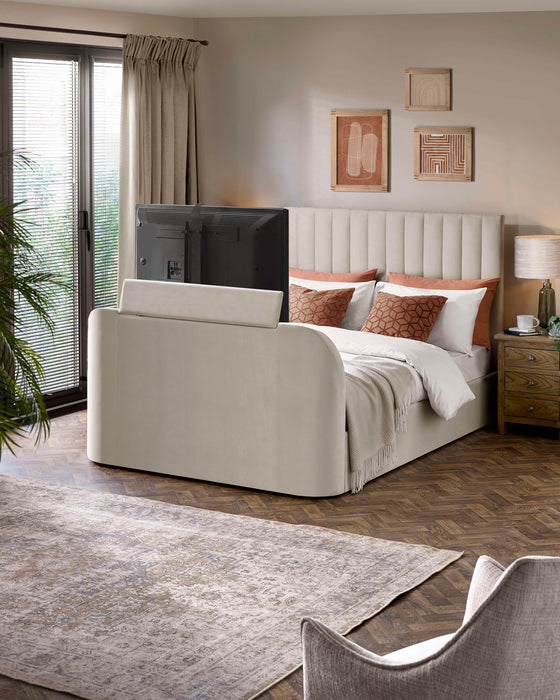 Julian Bowen Alana TV bed in cream velvet with the TV raised from the footboard, in a bedroom