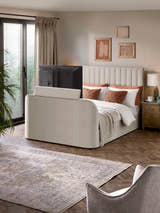 Julian Bowen Alana TV bed in cream velvet with the TV raised from the footboard, in a bedroom
