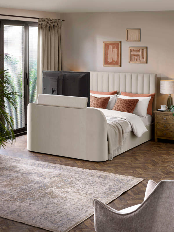Julian Bowen Alana TV bed in cream velvet with the TV raised from the footboard, in a bedroom