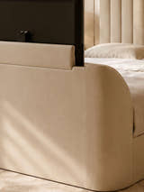 Alana TV bed: the TV lift rising from the curved footboard, close up