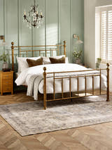 Julian Bowen Aurelia metal bed in brass effect, in a bedroom with green panelled walls