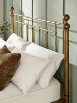 Aurelia bed: the brass effect headboard bars and round finial, with pillows