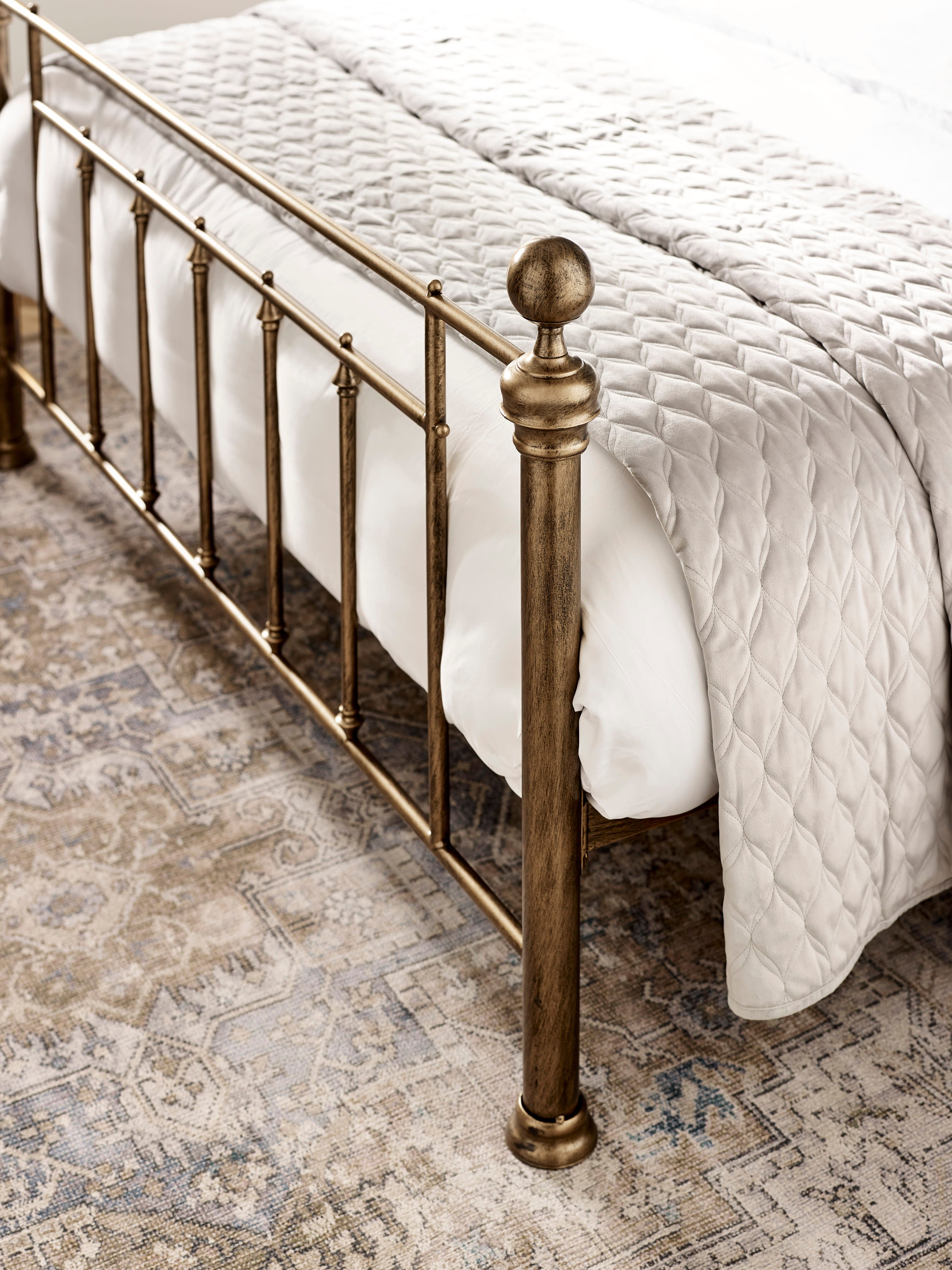 Aurelia bed: the brass effect footboard post and bars, close up