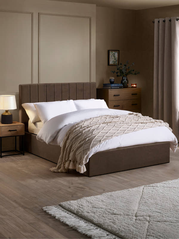 Julian Bowen Aylen ottoman bed in chocolate brown velvet with a channelled headboard, in a bedroom