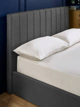 Aylen bed: dark grey headboard padded in vertical channels, close up