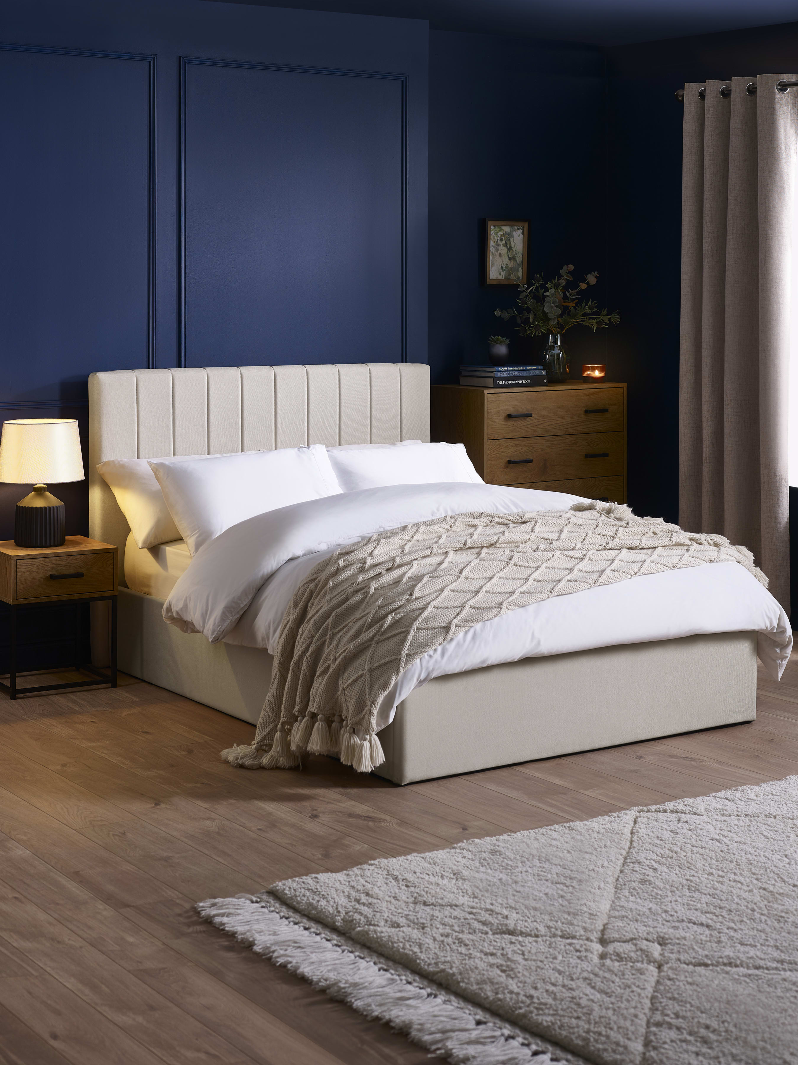 Julian Bowen Aylen ottoman bed in oatmeal linen effect fabric, in a bedroom with blue walls