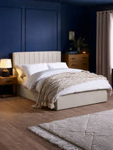 Julian Bowen Aylen ottoman bed in oatmeal linen effect fabric, in a bedroom with blue walls