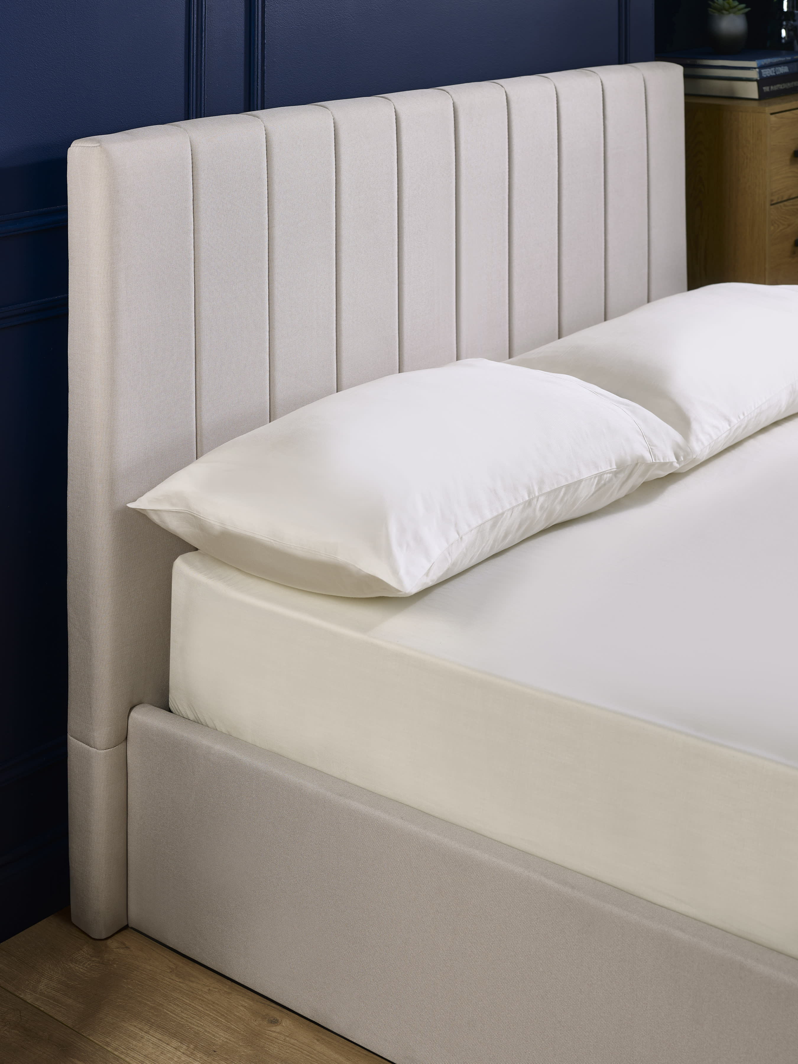 Aylen bed: oatmeal headboard padded in vertical channels, close up
