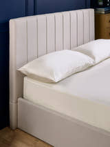 Aylen bed: oatmeal headboard padded in vertical channels, close up