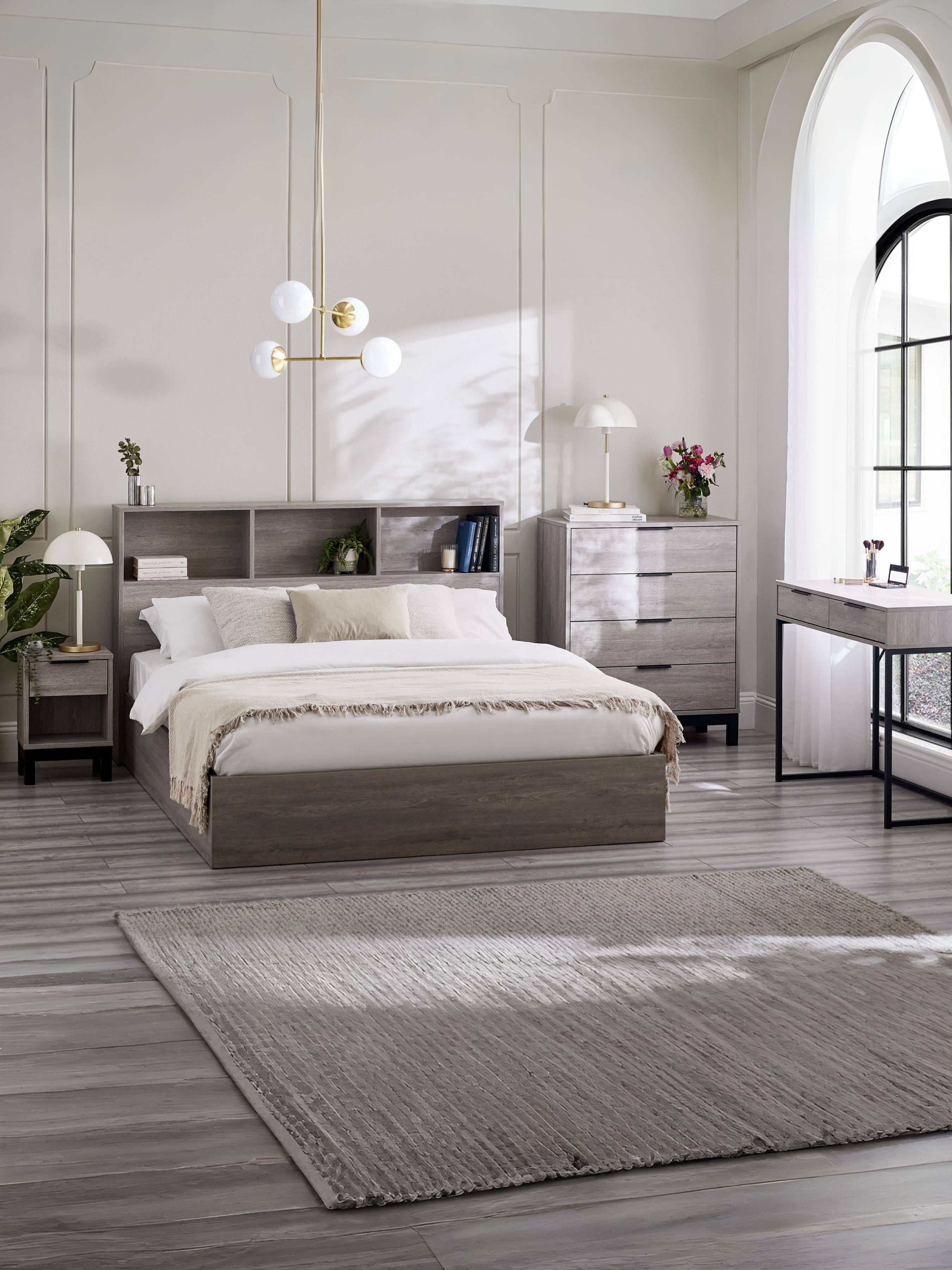 Julian Bowen Bali grey ottoman bed in a large bedroom with matching furniture, wide view