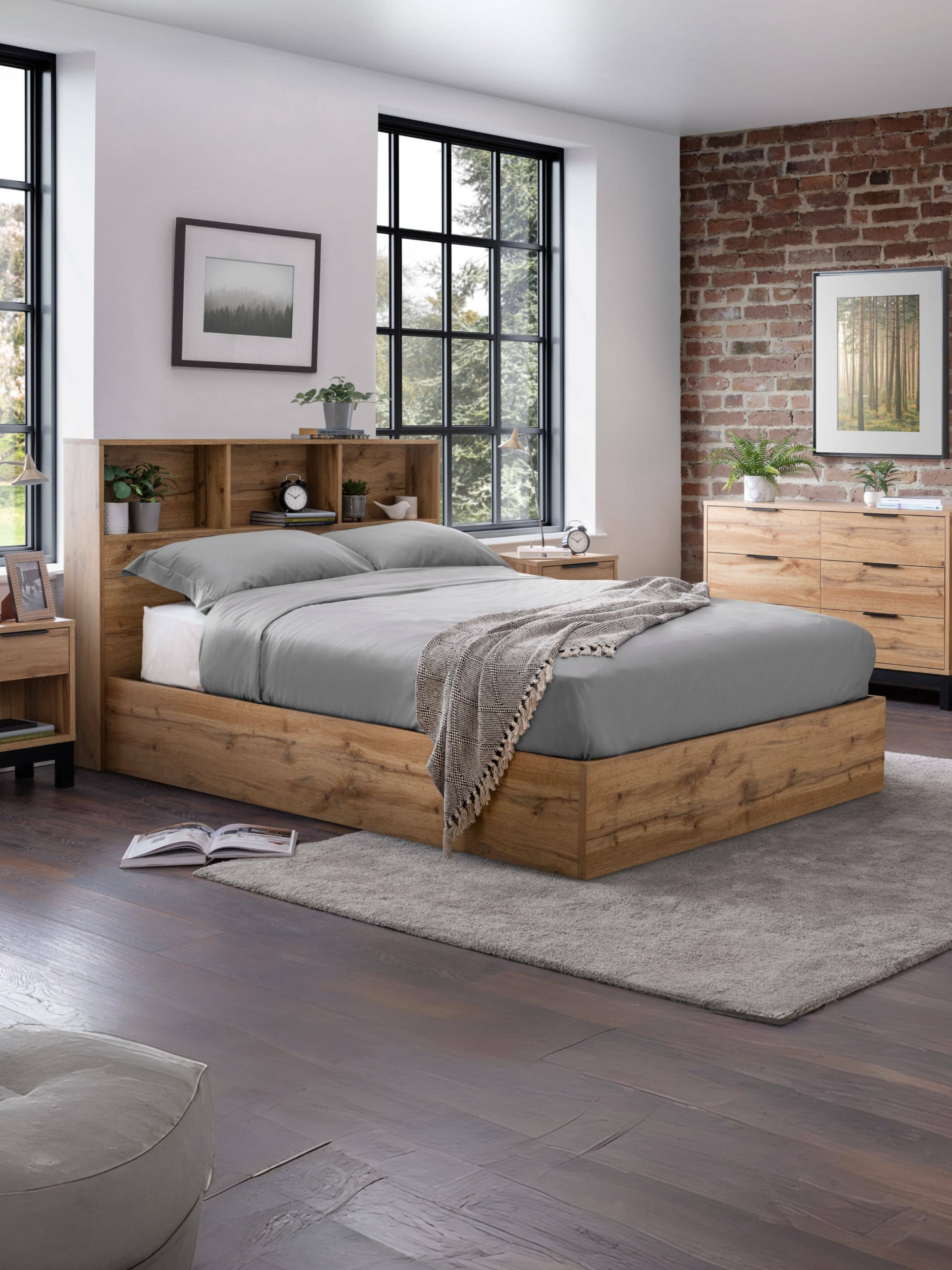 Julian Bowen Bali ottoman bed in light oak effect with a bookcase headboard, in a loft bedroom