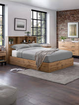 Julian Bowen Bali ottoman bed in light oak effect with a bookcase headboard, in a loft bedroom