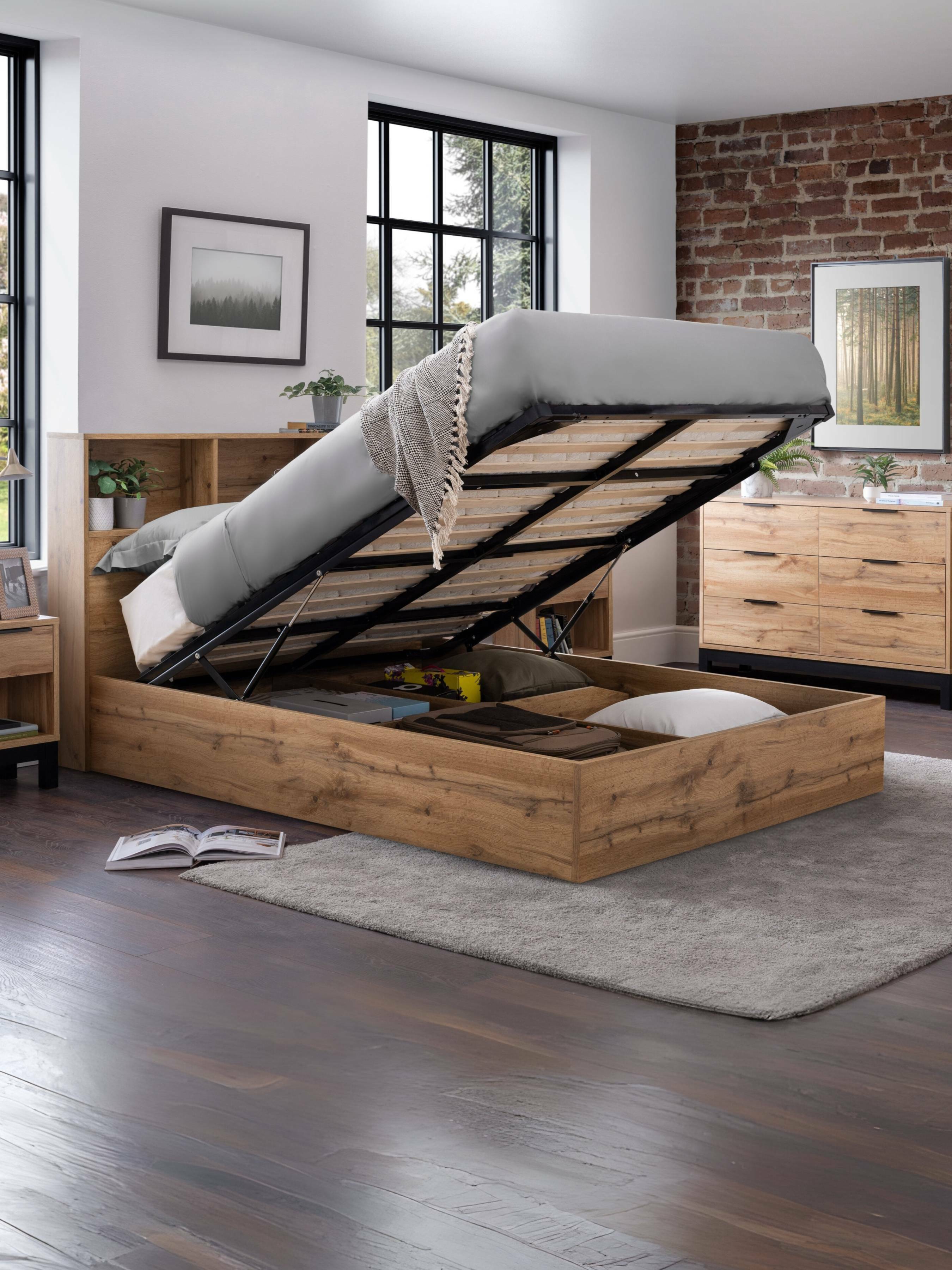 Bali light oak effect ottoman bed with the base raised over the storage, in a bedroom