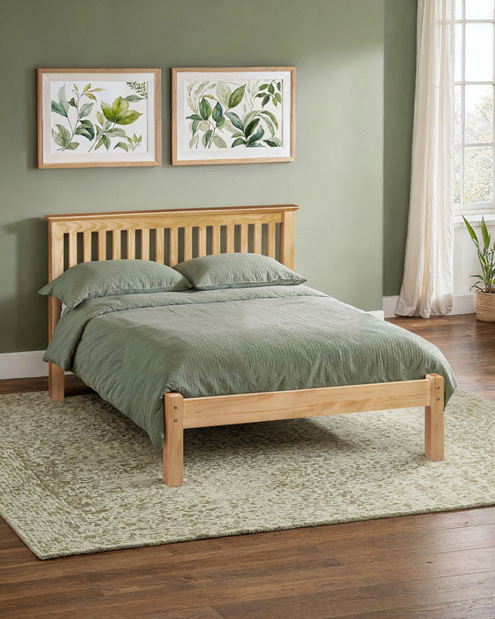 Julian Bowen Barcelona low footend bed in antique pine, in a bedroom with a green wall