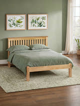 Julian Bowen Barcelona low footend bed in antique pine, in a bedroom with a green wall