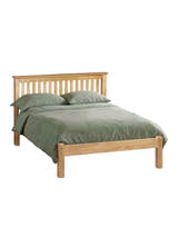Julian Bowen Barcelona antique pine bed made up with green bedding, on a white background