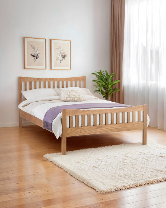 Julian Bowen Bergamo solid oak bed with a slatted headboard and footboard, in a bright bedroom